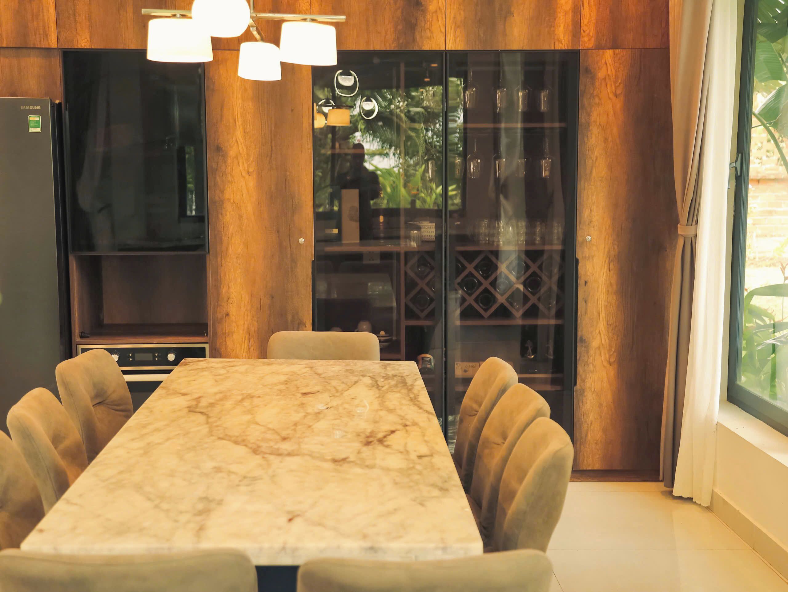 A modern kitchen with a marble countertop, wooden cabinets, and a built-in oven.