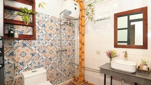 A bathroom with patterned tiles, a toilet, a sink with a mirror, and a shower area. - Apt*2BR  3 Beds in the center for 5 pax-Sunny homestay (Hà Nội)
