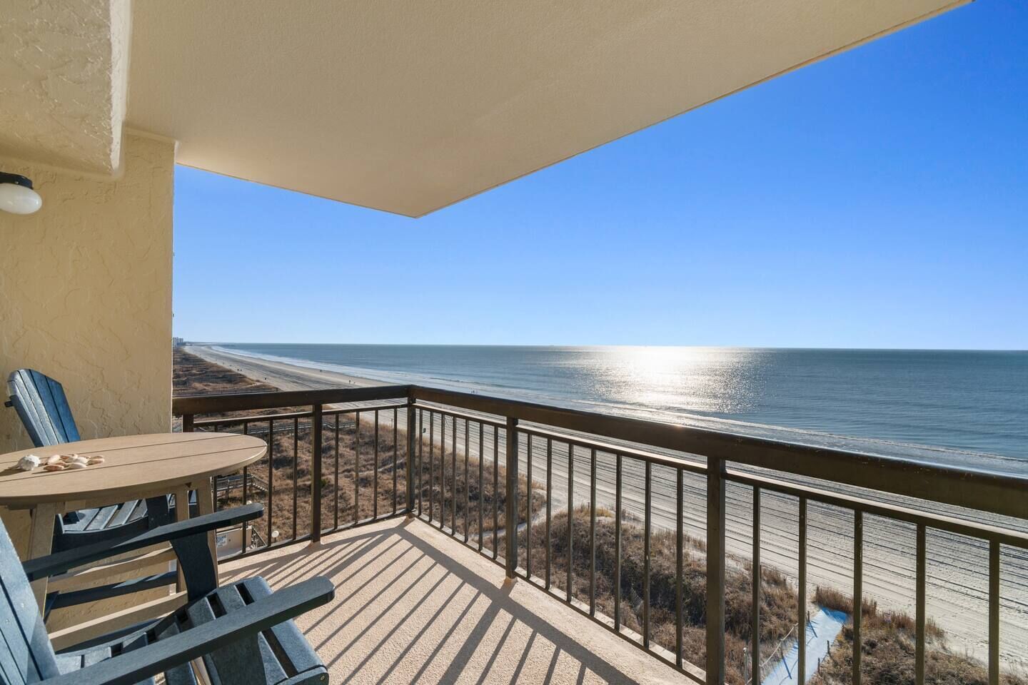 Een balkon met uitzicht op het strand en de oceaan.