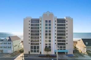 Ein mehrstöckiges Hotel mit einem zentralen Atrium in Strandnähe und freiem Blick auf das Meer.