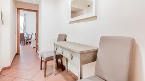 A clean, modern room with a desk, chair, and a large mirror on the wall. - Apartment located in the heart of Trastevere, a well-known central district of Rome.  (Roma)