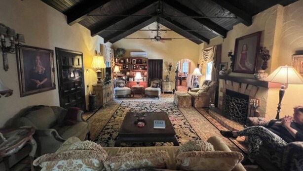 A cozy living room with a high ceiling, a fireplace, and a central coffee table.