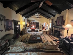 A cozy living room with a high ceiling, a fireplace, and a central coffee table. - Charming High Point Historical Home only minutes from HPU and Furniture Market (High Point)