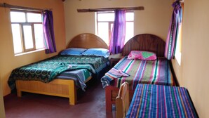 Ein Zimmer mit zwei Holzbetten, jeweils mit Kopfteil, und einem kleinen Tisch.