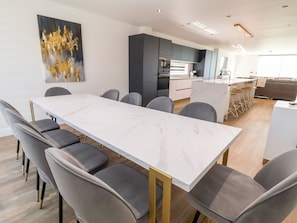 A modern kitchen with dark cabinets, a white countertop, and a built-in oven.