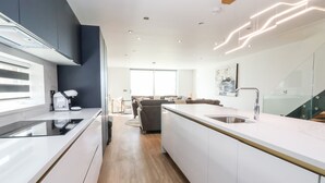 Eine moderne Küche mit Kochinsel, Backofen und Kaffeemaschine.