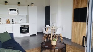 A modern apartment with a kitchen, dining area, and living space. - Appartement 2 Pièces Porto Vecchio (Porto-Vecchio)