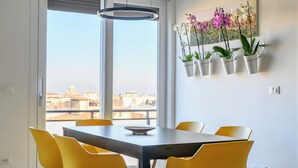 Un comedor con una mesa y sillas, una lámpara colgante y un arreglo de plantas en la pared.