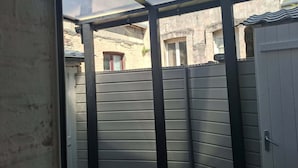 Un espacio exterior cercado con valla metálica y una puerta.