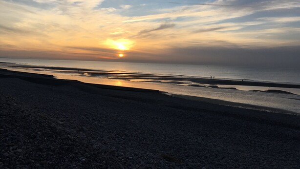 Una playa con un atardecer.