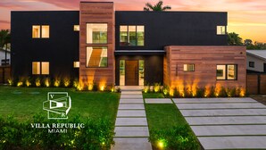 Een moderne villa met een tweetal verdiepingen, een zichtbare trap en een goed verlichte entree.