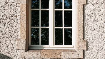 A window with a stone frame and a textured wall.