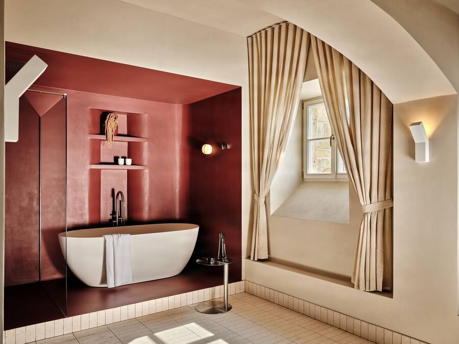A modern bathroom with a freestanding bathtub, a glass-enclosed shower, and a vanity with shelves.