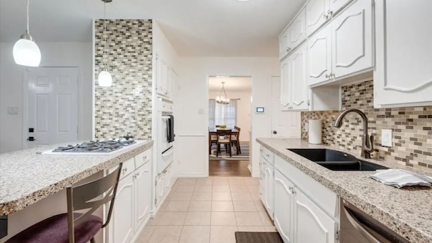 A modern kitchen with white cabinetry, a tiled backsplash, and granite countertops. - Game-Day Getaway NEW Stadium View Walk to ATT or Rangers (Arlington)
