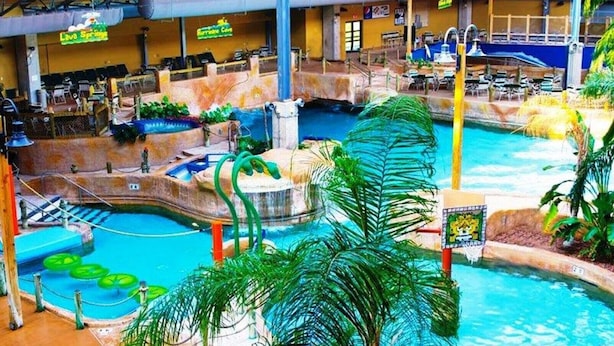 Un parc aquatique intérieur doté de plusieurs piscines, de toboggans et d’une cascade.