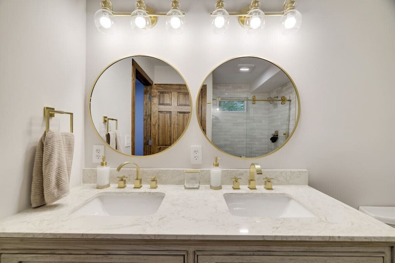 Un baño con dos lavamanos, un espejo grande y una ducha.