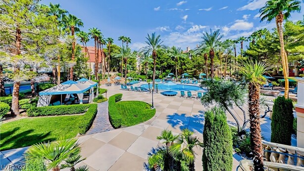 Un resort con piscina, sillas de descanso y palmeras.