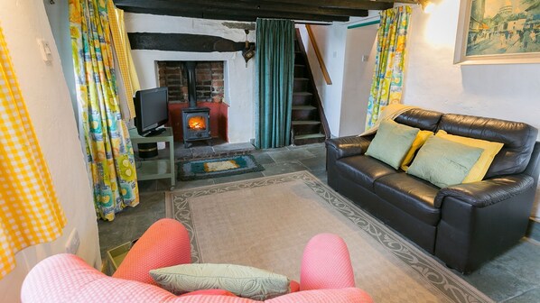 A cozy living room with a fireplace, a sofa, and a television.