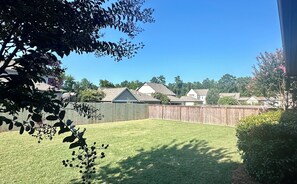Enjoy a serene natural setting surrounded by trees and shrubs in this beautifully maintained backyard.