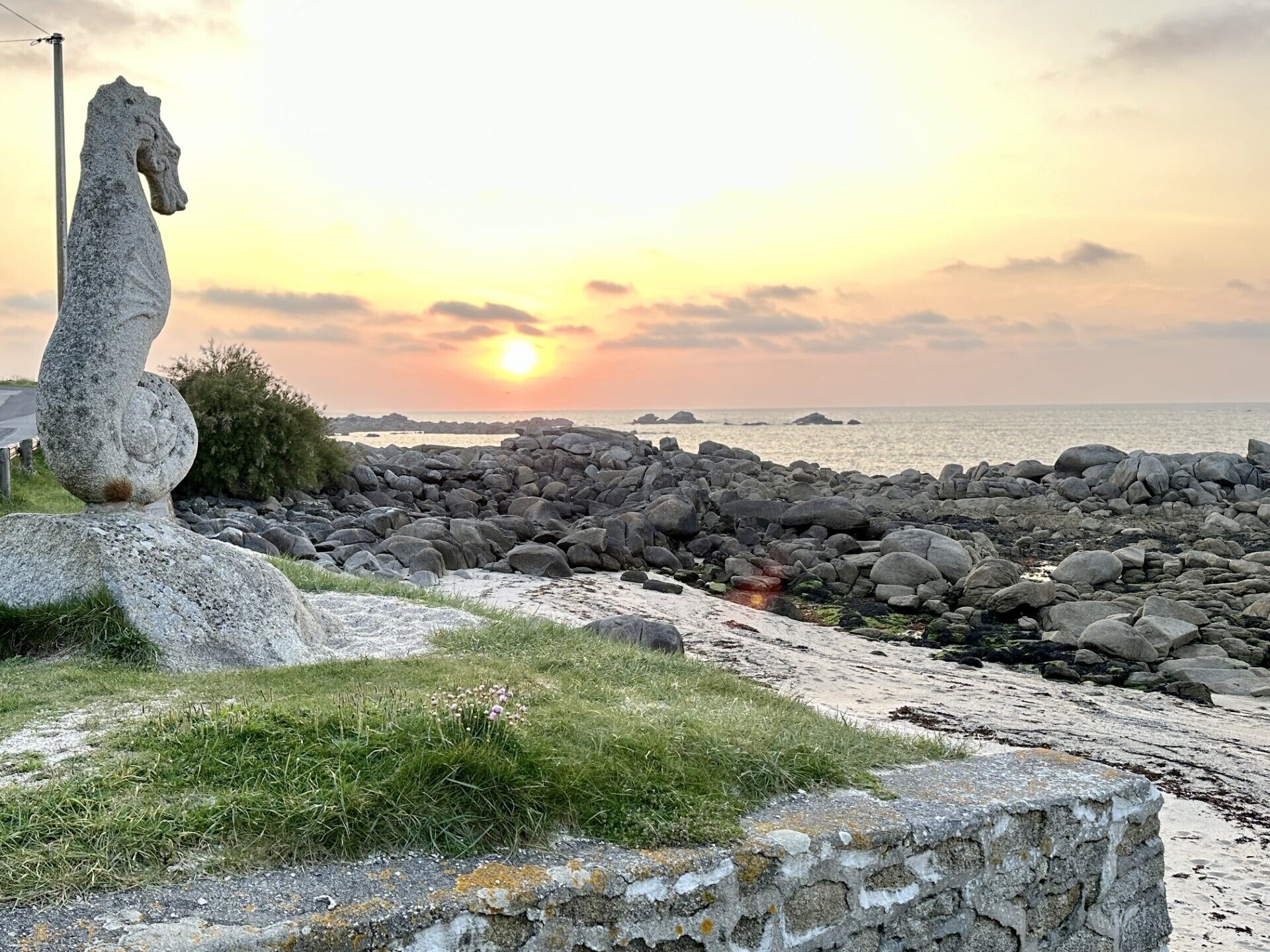Ein Stehpferd-Denkmal am Meer bei Sonnenuntergang.