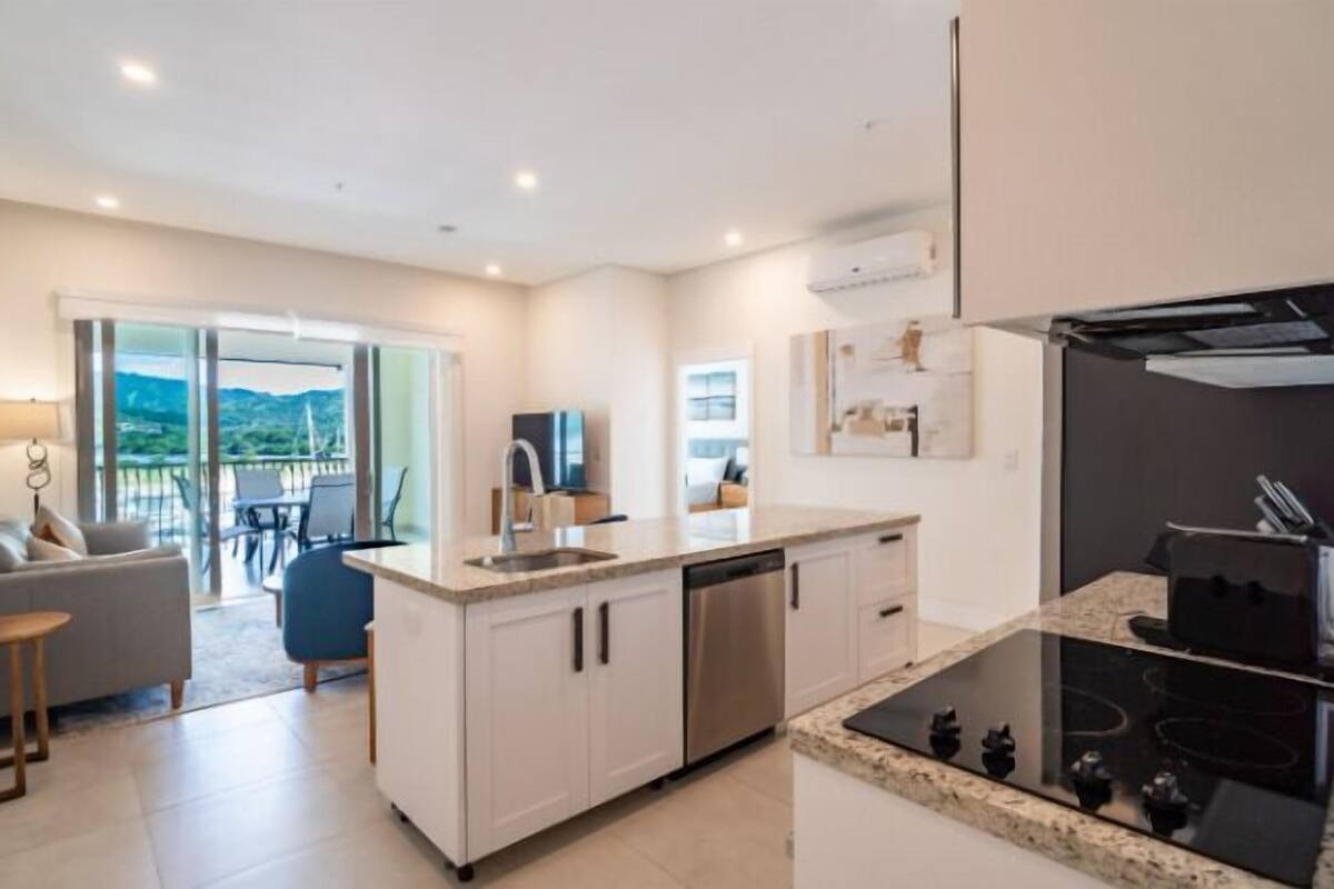 A modern kitchen with a central island, built-in appliances, and a view to the outdoors.
