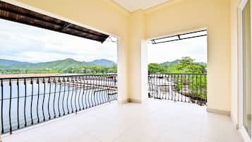 A balcony with a view of a river and mountains.
