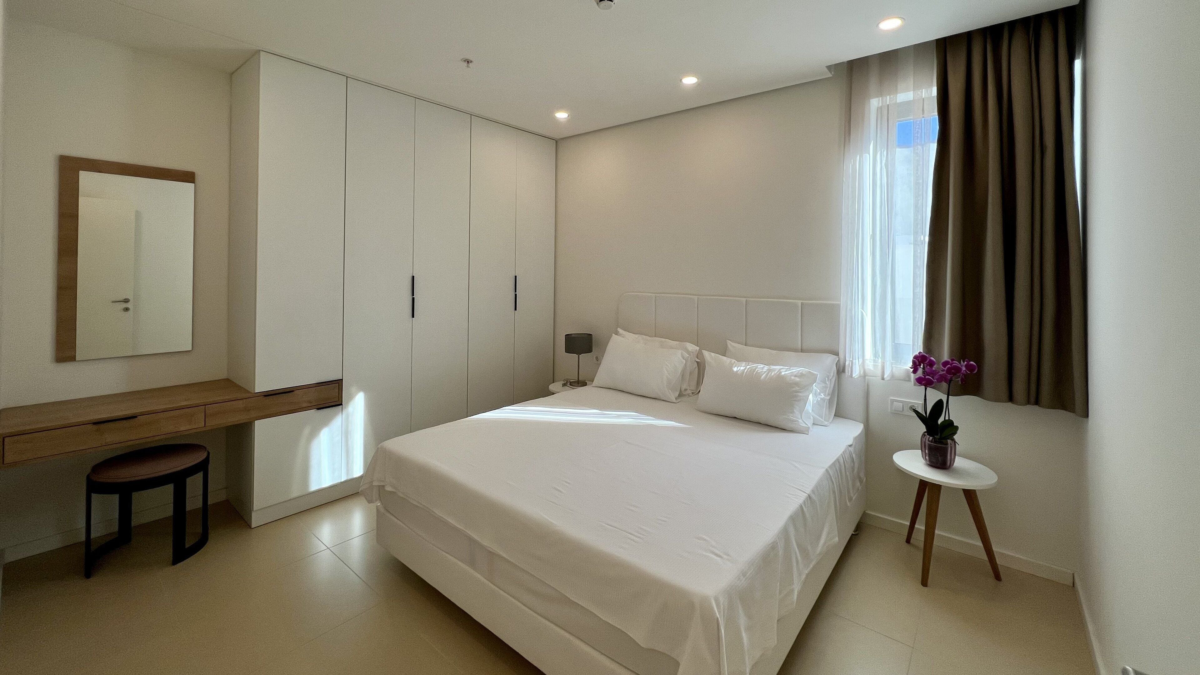 Une chambre moderne avec un grand lit, un bureau et une chaise.