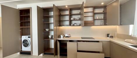 A modern kitchen with built-in appliances, open shelving, and a countertop with a toaster.