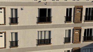 Un immeuble à plusieurs étages, doté d’une façade uniforme, avec des fenêtres régulièrement espacées et des balustrades noires.