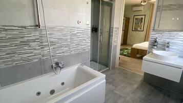 Deluxe-Dreibettzimmer | Badezimmer | Badewanne und Dusche (separat), Whirlpool, Hydromassagedusche
