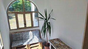 Ein gemütlicher Winkel mit einer Bank, einer Topfpflanze und einem Willkommensschild.