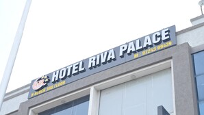 Ein Schild des Hotels 'Hotel Riva Palace' im dritten Stock eines Gebäudes.