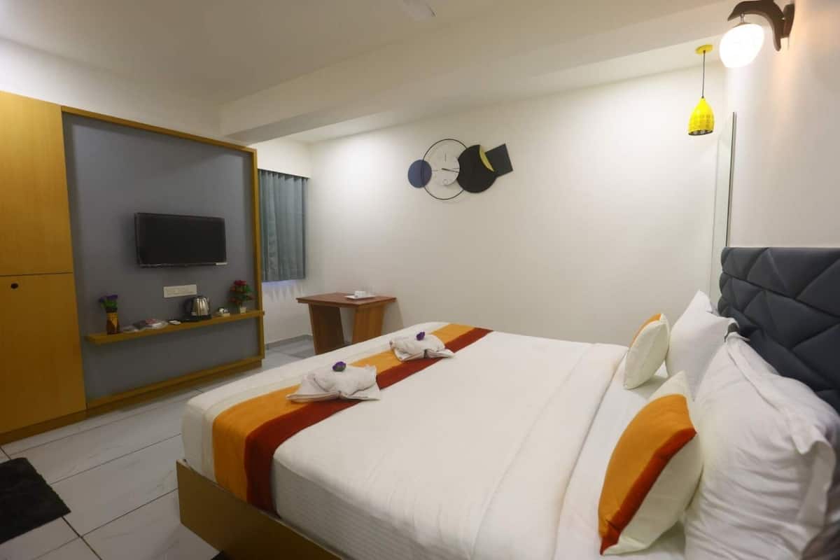 Une chambre d’hôtel équipée d’un lit, d’une télévision, d’un bureau et d’une armoire.