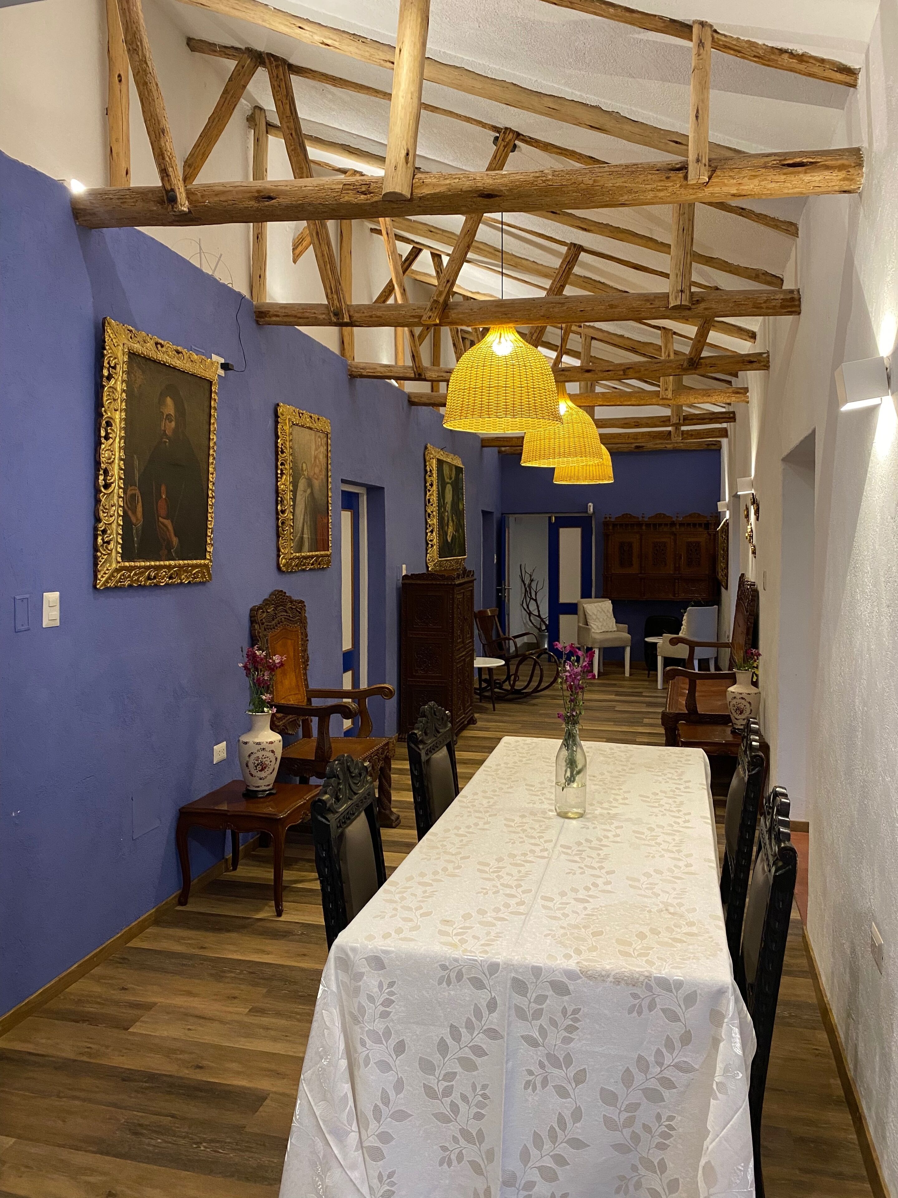 Un comedor con una mesa larga, sillas de madera y un candelabro.
