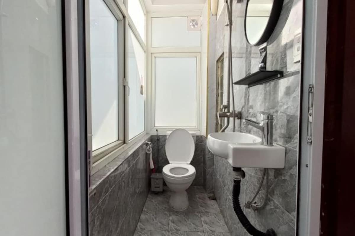A compact bathroom with a toilet, sink, and a window.