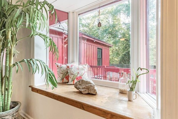 A window ledge with a potted plant, a rock, and a small vase with a plant. - Farmhouse & Cottage near DT, USC (Lexington County)