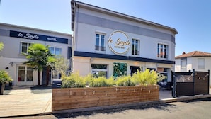 Un hotel con un letrero que dice "le Smile HOTEL BAR" y una jardinera de madera con plantas al frente.