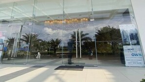 Una entrada moderna a un edificio con fachada de vidrio y estructura metálica.