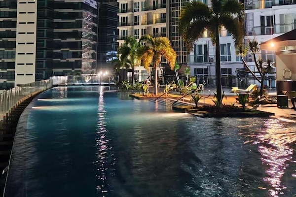 Una piscina al aire libre, sillones reclinables de piscina