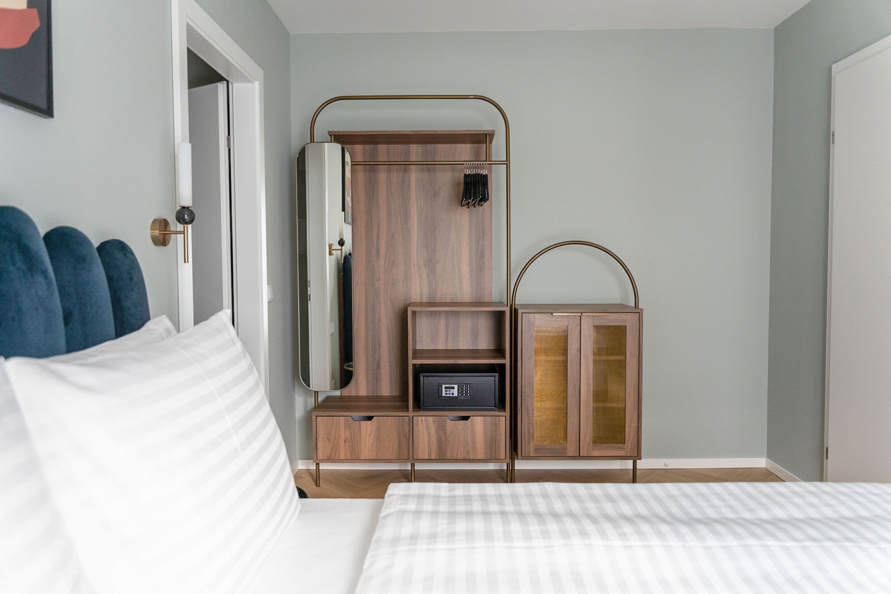 Een slaapkamer met een bed, een kledingkast, een nachtkastje en een hanglamp.
