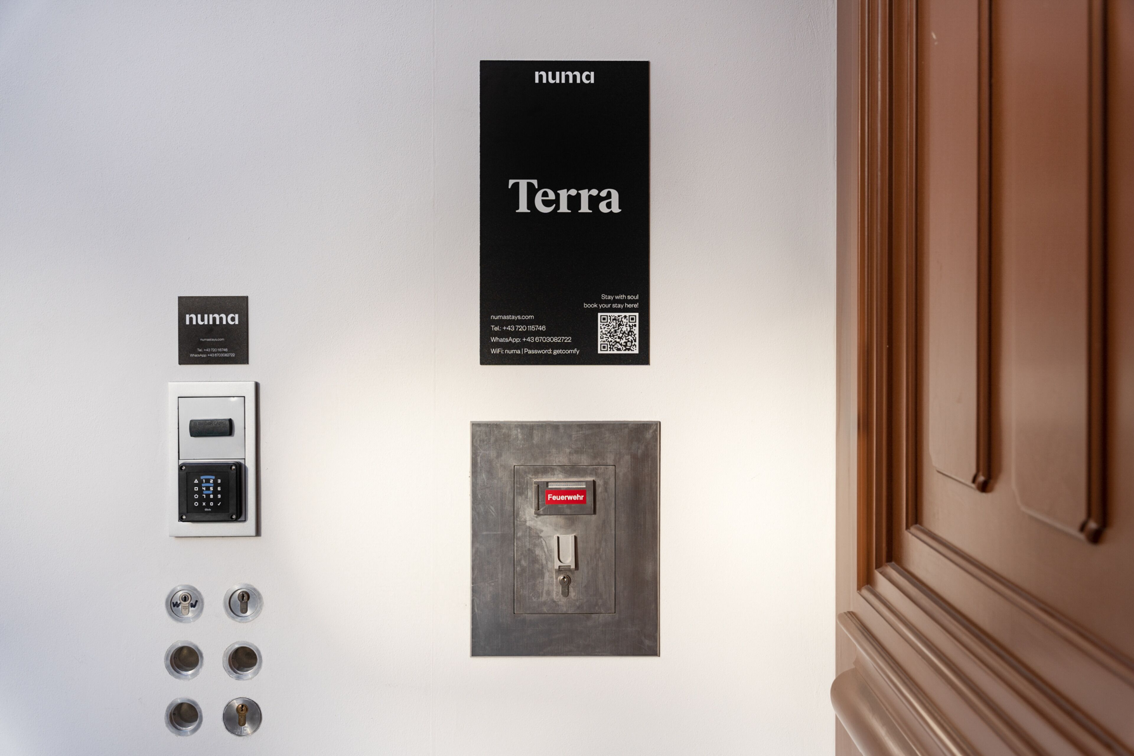 Pannello di sicurezza montato a parete con tastierino numerico, serratura per porta e allarme incendio.