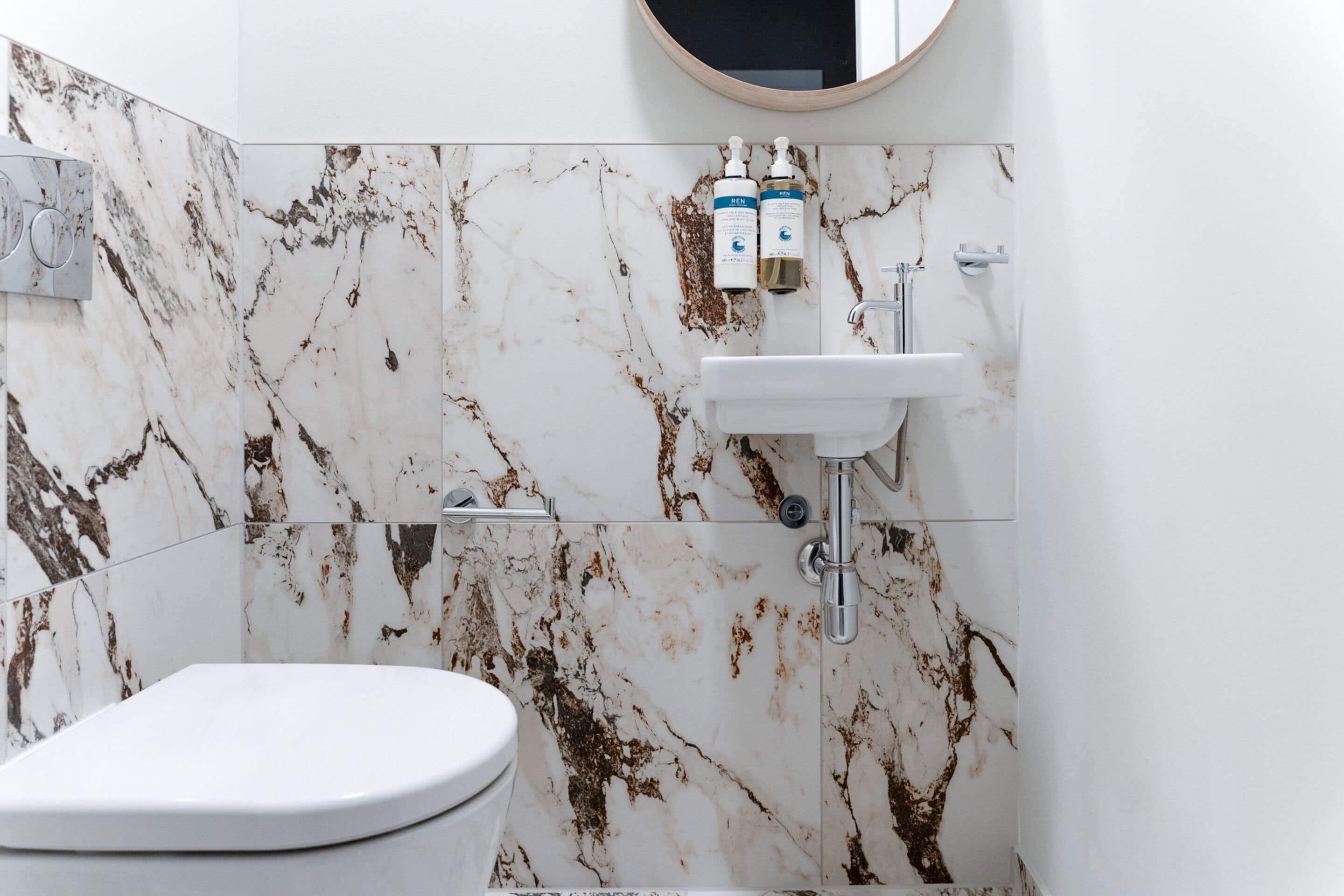 A bathroom with a white toilet, a sink, and a shower.