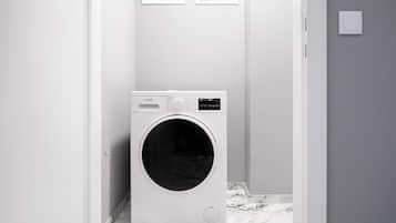 A compact, modern laundry room with a front-loading washing machine, a small control panel, and a wall-mounted vent.
