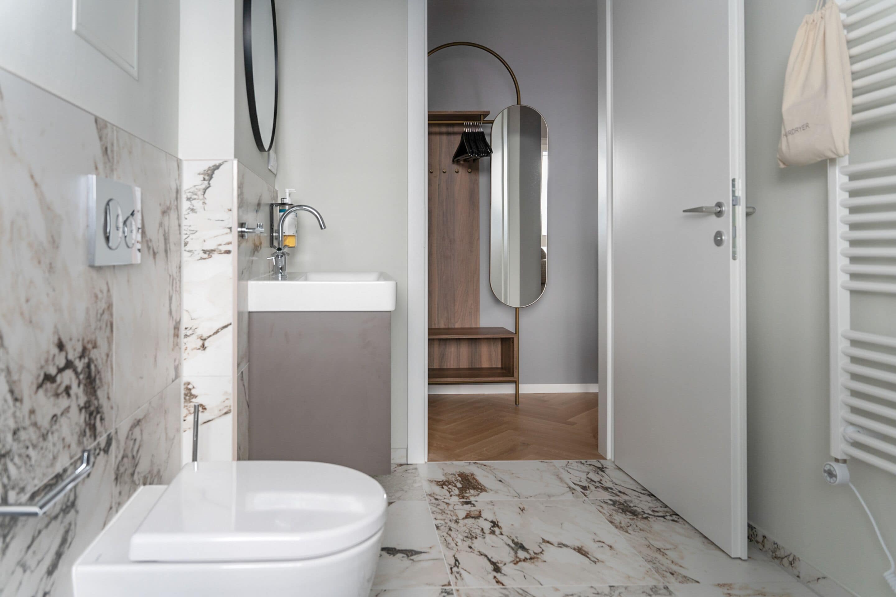 A modern bathroom with a white toilet, a sink, and a mirror.