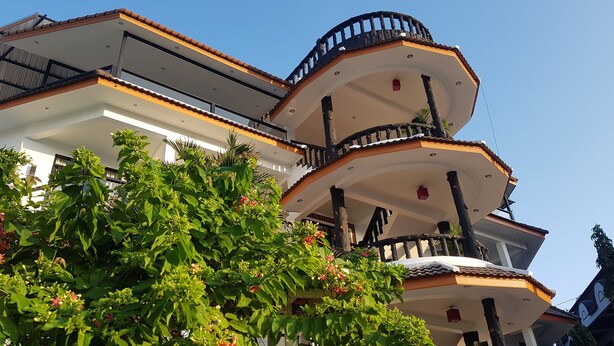 A multi-story building with balconies and a garden area. - La Capannina Ristorante & Hotel Patong (Patong)