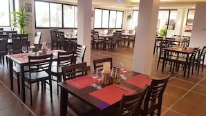 A restaurant with multiple tables and chairs, each set with wine glasses, cutlery, and napkins. - La Capannina Ristorante & Hotel Patong (Patong)