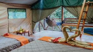 Una habitación acogedora con dos camas, una hamaca y una escalera de madera.
