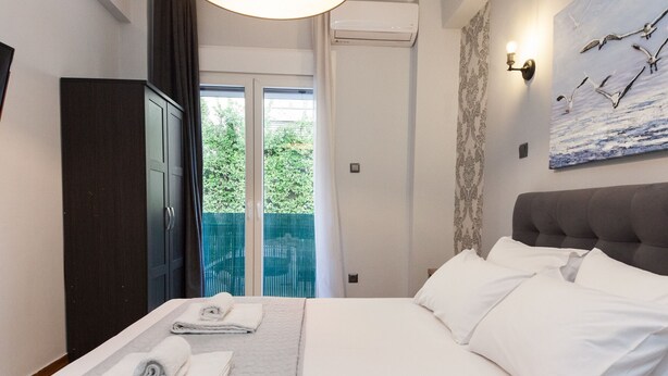 Hotelkamer met een bed, een garderobe, een schilderij en uitzicht op groen.