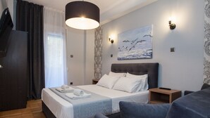 Een moderne slaapkamer met een groot bed, nachtkastjes, een kledingkast en een schilderij aan de muur.