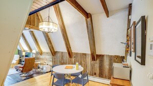 Un'accogliente sala da pranzo con un tavolo rotondo, sedie e un lampadario.